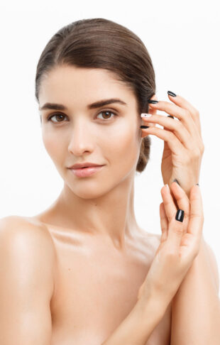 Beauty and Skin care concept - Close up Beautiful Young Woman touching her skin on white background.